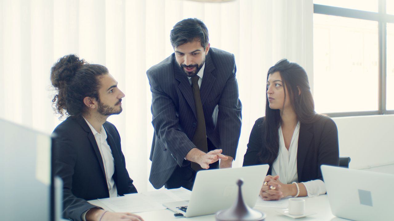 our-journey-01 Professional team in office discussing a business project with focused collaboration.